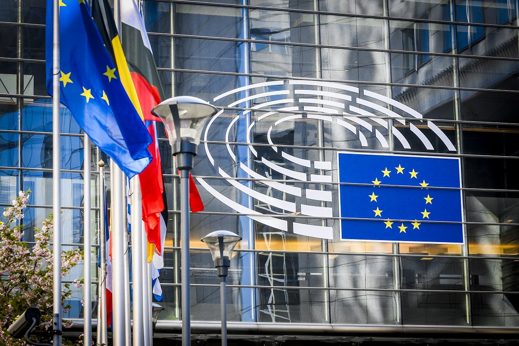 Imagen exterior de edificio del Parlamento Europeo en Bruselas con banderas